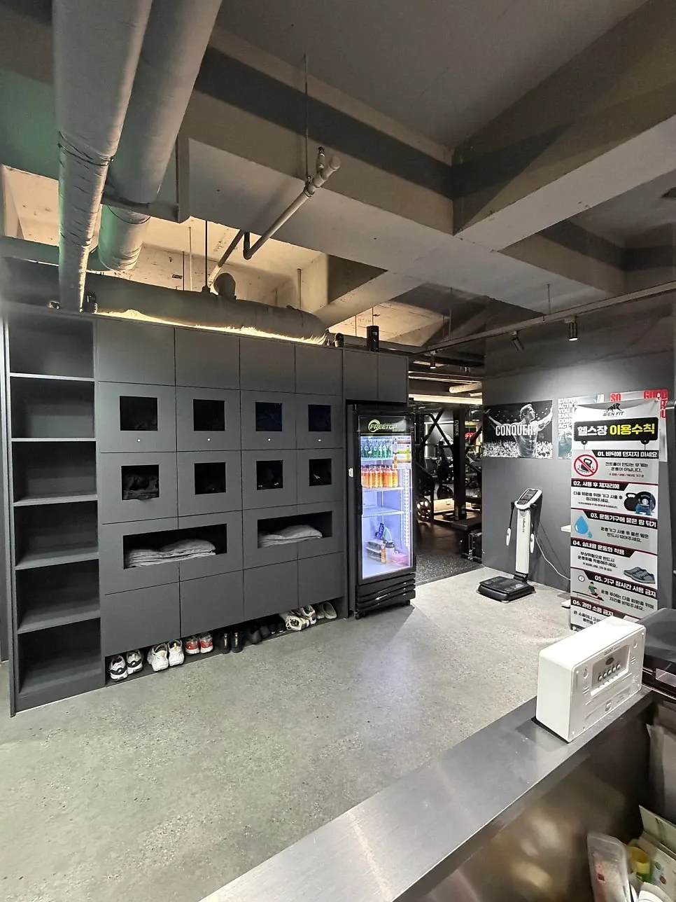 비앤핏 입구 내부의 운동복·수건 수납장과 신발, 체성분 측정 기기