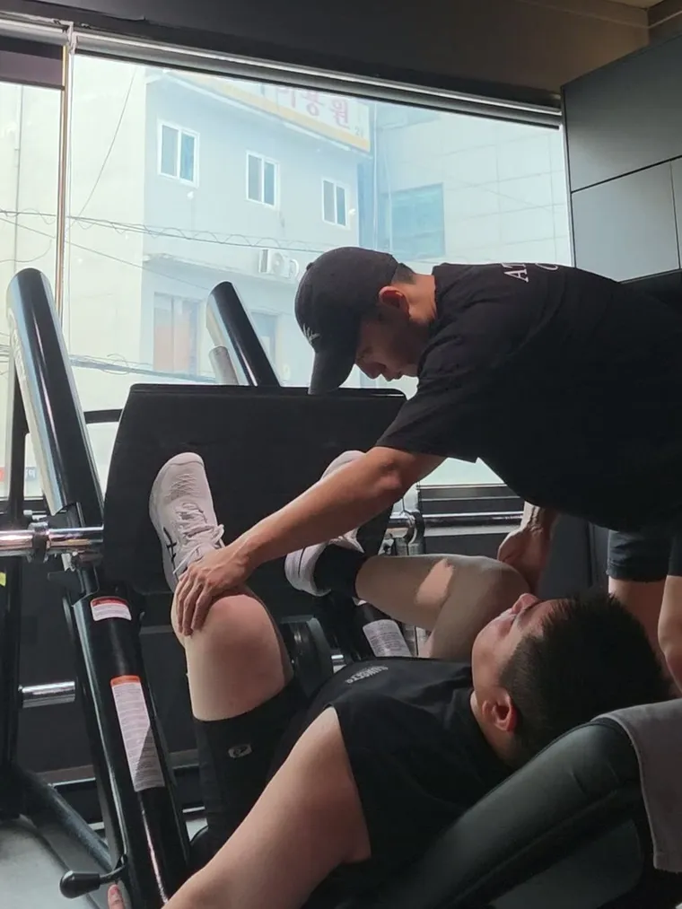 비앤핏 1:1 PT — 김상현 트레이너가 레그프레스 자세를 잡아 주는 수업 장면